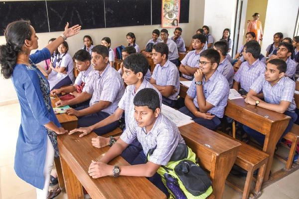 Teachers communicating with students and using digital systems in Goa schools.